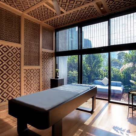 The Ruma Hotel And Residences Kuala Lumpur Eksteriør billede The photo displays a tranquil room designed for relaxation or therapy. The room features a massage table centered in the space, with elegant wooden accents. The walls are adorned with intricate geometric patterns, contributing to a serene atmosphere.
