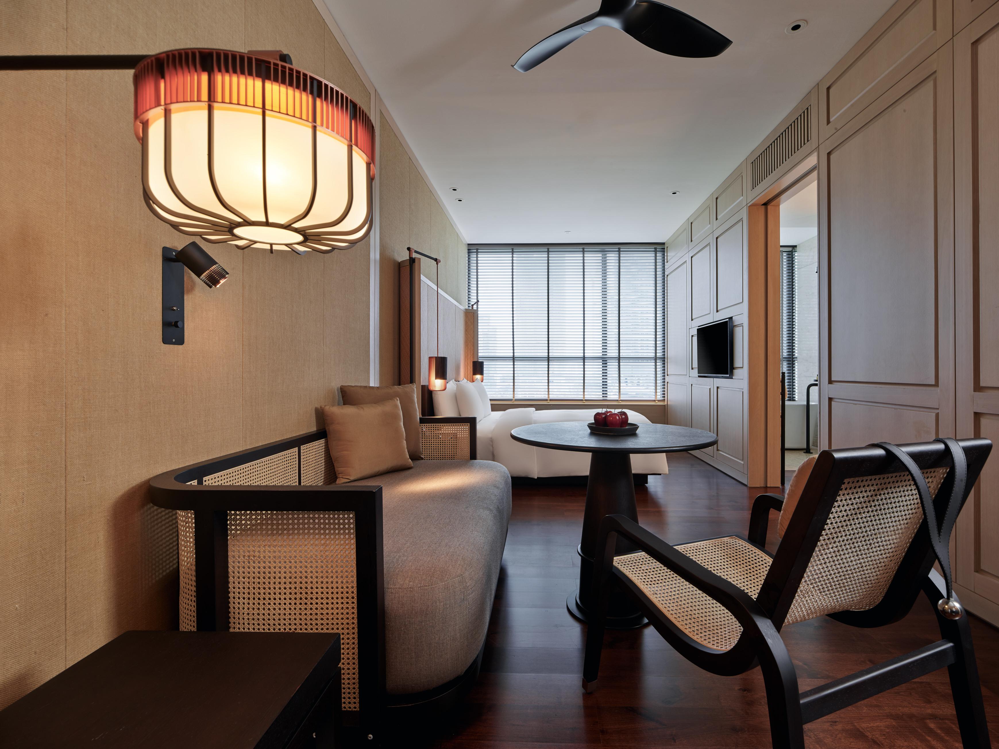 The Ruma Hotel And Residences Kuala Lumpur Eksteriør billede The photo shows a stylish and modern interior of a hotel room or a living space. The decor features warm tones and natural materials, with a wall finished in light wood or beige. 

In the foreground, there is a round table with a small decorative ite