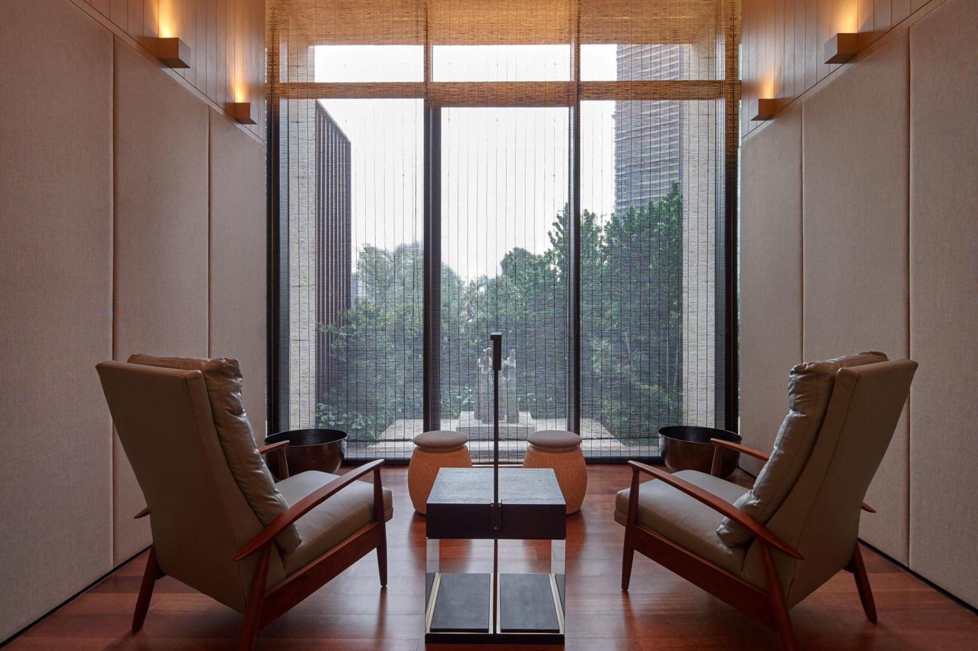 The Ruma Hotel And Residences Kuala Lumpur Eksteriør billede The photo depicts a minimalist interior space, featuring two stylish chairs positioned across from each other. Between them, there's a sleek table with a simple design. The walls are finished with a light color, contributing to a serene ambiance. Lar